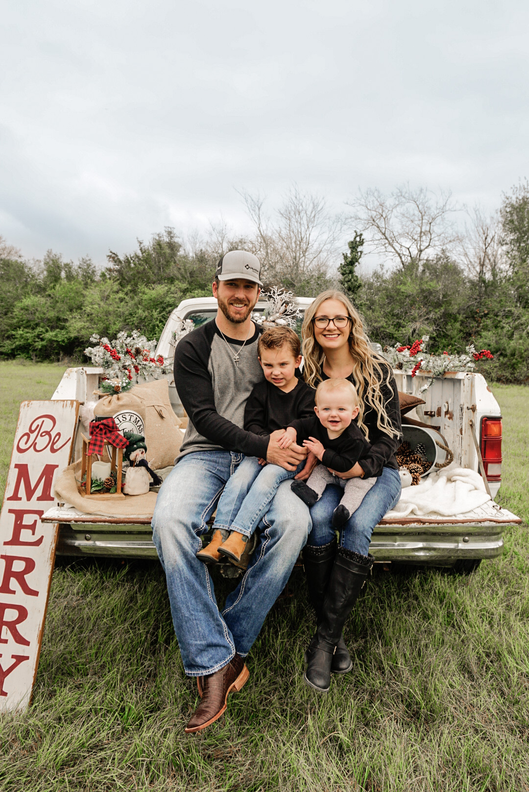 Co-owner, Reed Loewe and family portrait sitting on white truck in field