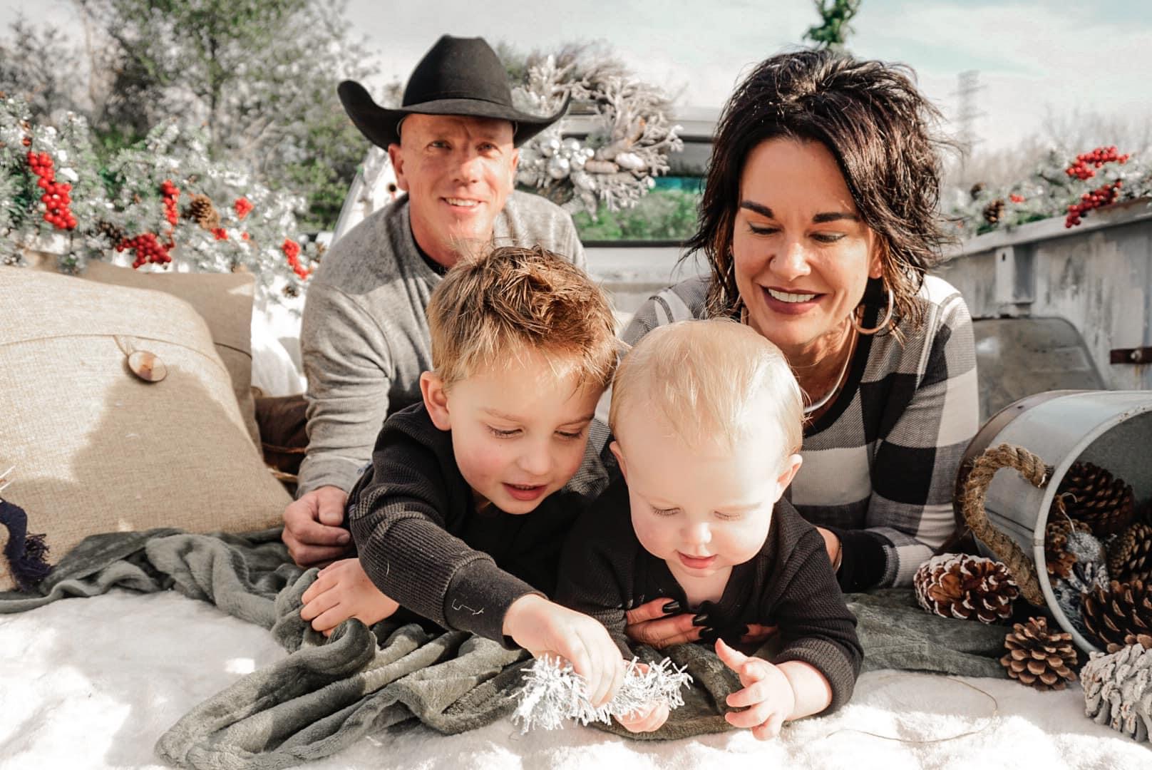 Co-owner, Ryan Loewe and family portrait sitting on white truck in field